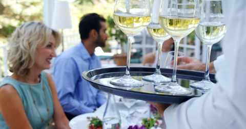 Outdoor dining experience with white wine and conversation