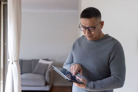 Senior man using tablet in bright living room