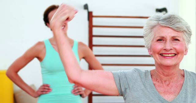 Elderly woman enjoying workout in gym, promoting health and wellness. Suitable for topics on physical fitness, senior health, and positive aging. Perfect for advertisements and articles on active senior lifestyles, fitness programs for older adults, and maintaining well-being in later years.