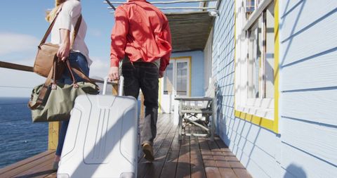 Couple arriving at beach house with luggage