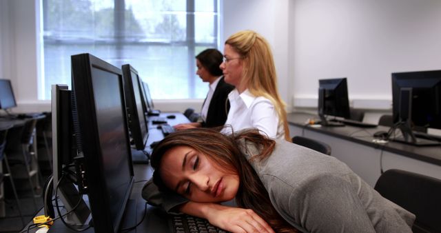 Tired Businesswoman Sleeping at Office Desk with Colleagues Working - Download Free Stock Images Pikwizard.com