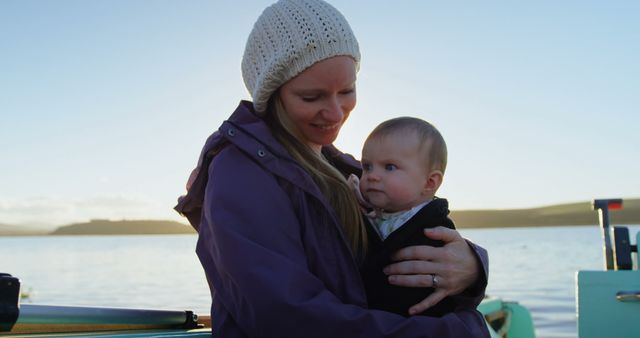 Mother Holding Baby Enjoying Calm Boat Ride at Sunset - Download Free Stock Images Pikwizard.com