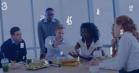 Team collaborating over tablet during working lunch in modern office with takeout food