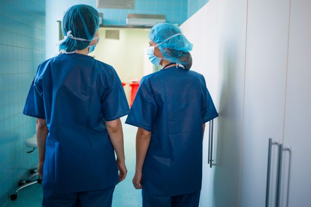 Rear view of surgeons standing in corridor at hospital