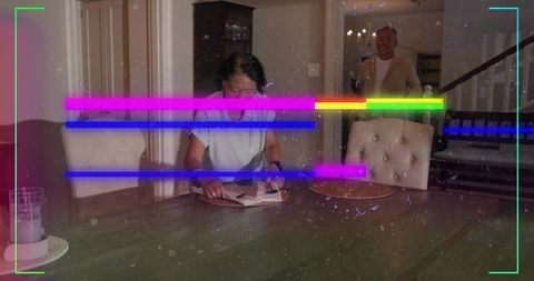 Chinese woman placing napkin at dining table with senior man and neon glitch overlay