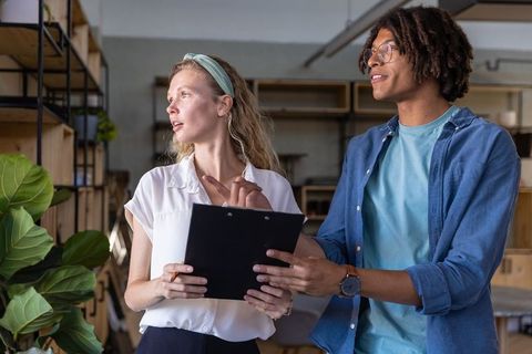 Team collaboration in modern office with clipboard discussion