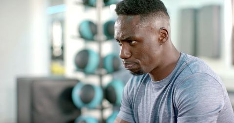 African american athlete catching breath after intense workout, sweat and determined focus