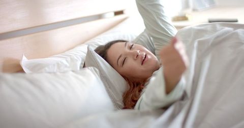 Biracial Woman Stretching in Bed During Morning Wake-up Routine - Download Free Stock Images Pikwizard.com