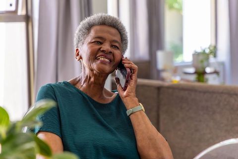 Senior african american woman talking on smartphone at home smiling and relaxed