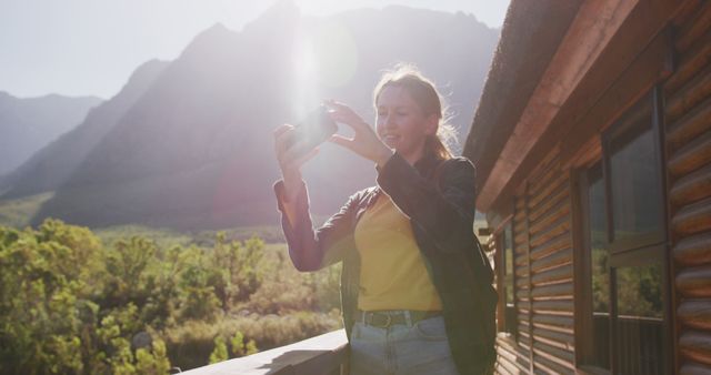 Woman Taking Photograph Outdoors During Sunset Near Cabin - Download Free Stock Images Pikwizard.com