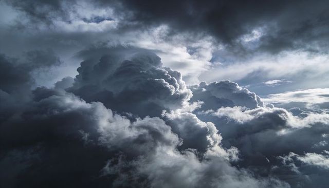 Towering Cumulonimbus Clouds Gathering with Silver Linings and Sunbeams