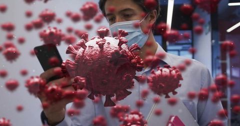 Man wearing surgical mask checking smartphone with floating coronavirus particles overlay
