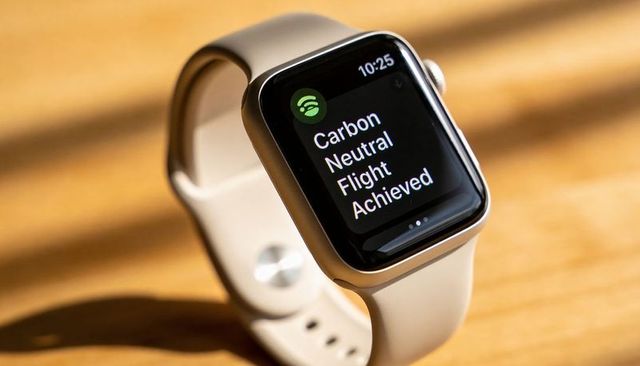 Sunlit smartwatch showing carbon neutral flight achieved notification on sport band