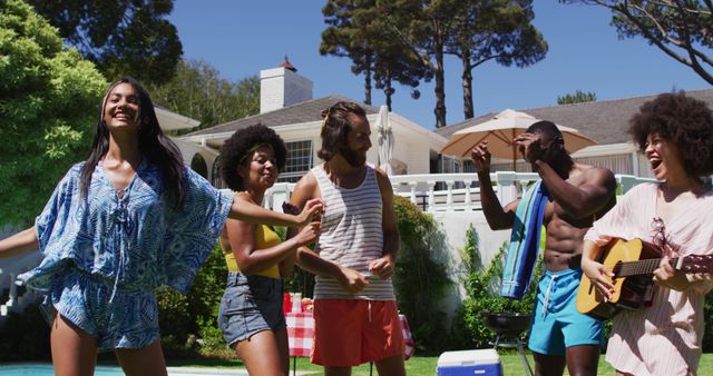 Diverse group of friends having fun and dancing at a pool party. Hanging out and relaxing outdoors in summer.