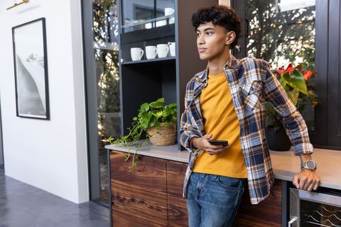 Asian Man Relaxing in a Stylish Lounge with Smartphone