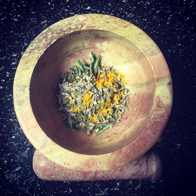 Organic herbs and spices sitting in a marble mortar and pestle. Ideal for illustrating culinary preparation, cooking classes, and recipes. Useful for food bloggers, cookbooks, and dietary content.