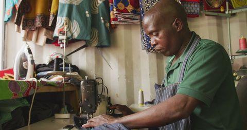 African tailor sewing in cape town workshop with sewing machine