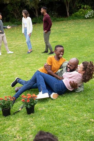 Diverse family enjoying playtime on lush green lawn