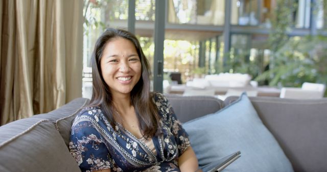 Smiling Woman Sitting on Couch Using Tablet in Modern Home - Download Free Stock Images Pikwizard.com