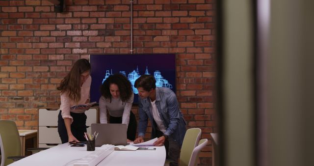 Caucasian businessman, a biracial and a Caucasian businesswomen working in a modern office together, brainstorming using laptop, 3d architectural model on screen. Business creativity technology.