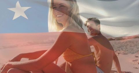 Smiling couple relaxing on beach with chile flag overlay promoting summer travel