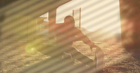 Backlit Urban Athlete Stretching under Overpass