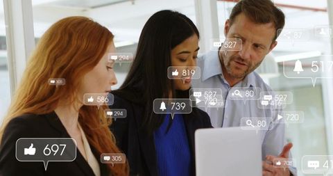 Team Collaborating Over Laptop With Social Media Engagement Overlays in Modern Office