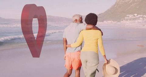 Senior couple embracing ocean breeze on serene beach stroll