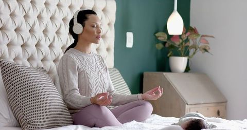 Calm Mother Meditating with Baby in Relaxed Bedroom Environment
