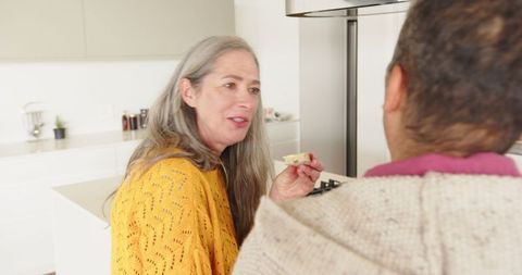 Senior Mother and Son Chatting in Modern Kitchen