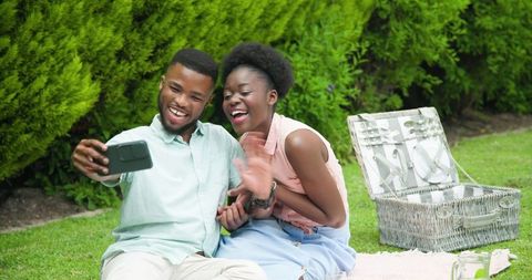 Joyful African American Couple Enjoying Picnic in Park Taking Selfie