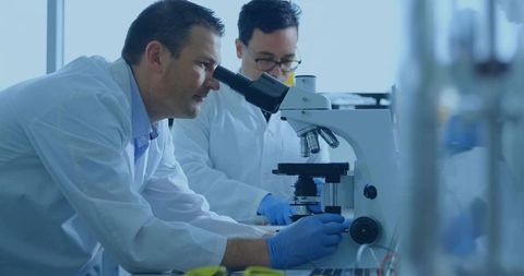 Scientists conducting microscope research in lab