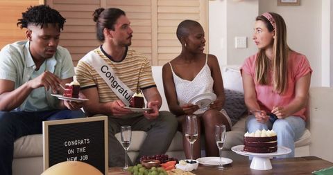 Friends Celebrating New Job at Home with Cake and Snacks