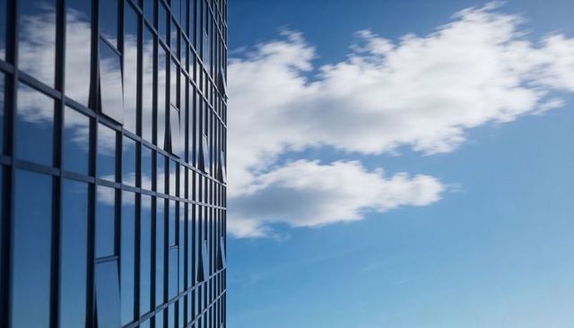 Modern Glass Facade Reflecting Blue Sky with Venting Windows and Minimalist Copy Space