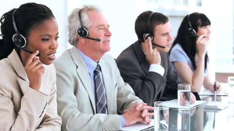 Diverse Business Team Using Headsets at Conference Table
