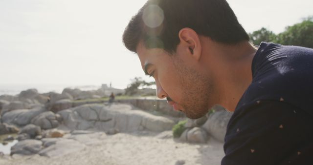 Reflective Young Man Contemplating Rocks by the Sea - Download Free Stock Images Pikwizard.com