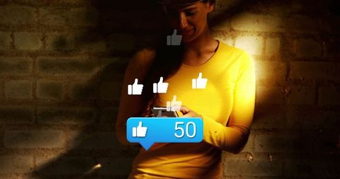 Young woman engaging social media on mobile with floating likes and 50 badge, moody spotlight