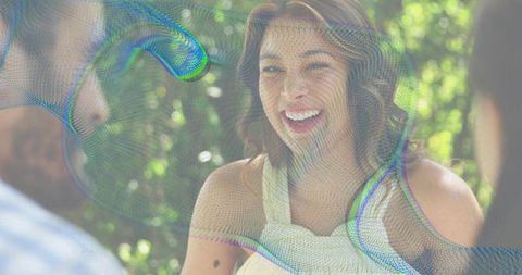 Laughing woman socializing in sunny garden with iridescent abstract overlay effect