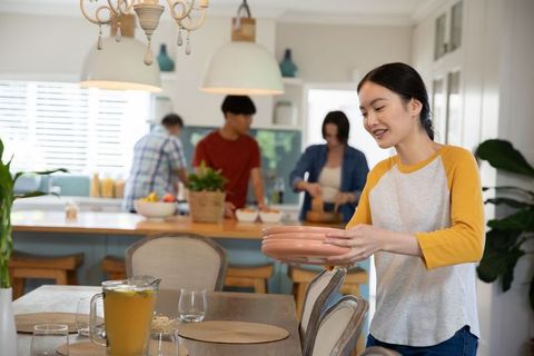 Asian woman hosting family lunch in modern kitchen