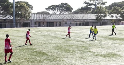 Soccer Players on Field, Team Relaxed After Match on Sunny Day