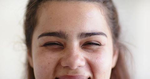 Close-up african american woman laughing with eyes closed radiant natural smile