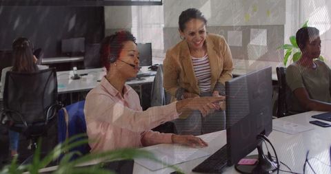 Businesswoman guiding colleague in modern office environment