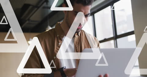 Innovative Young Professional Using Laptop with Digital Triangles
