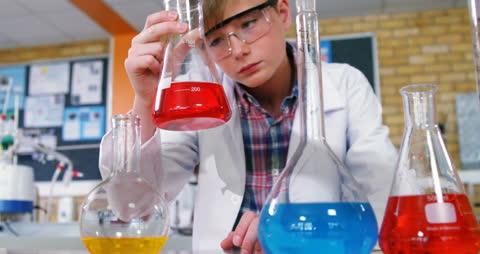 Caucasian Boy Conducting Science Experiment in Classroom