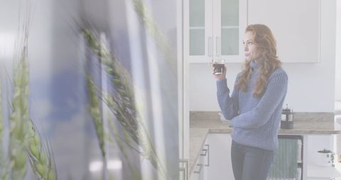 Woman Relaxing with Coffee in Modern Kitchen with Overlay of Wheat Field