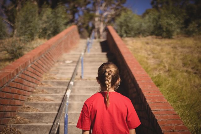 Rear view of girl standing near staircase during obstacle course in boot camp