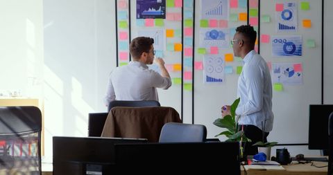 Colleagues Discussing Strategy in Modern Office Surrounded by Data