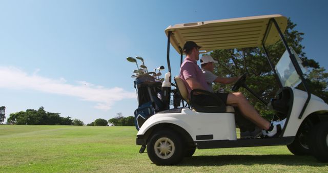 Happy caucasian male golf players talking and riding golf cart at golf course, copy space. Golf, sport and active lifestyle, unaltered.