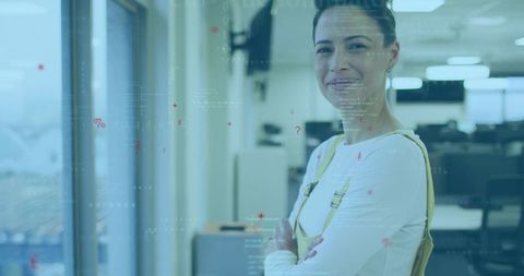 Confident businesswoman standing in modern office showing data overlay and city view