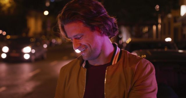 Young Man Smiling at Night in City Street Lit by Car Headlights - Download Free Stock Images Pikwizard.com